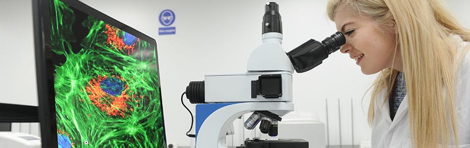 Laboratory science- girl looking down microscope